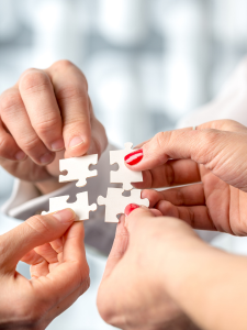 Des mains qui tiennent des pièces de puzzle pour le compléter